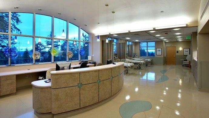 Hospital nurses station and patient care area with curved reception casework
