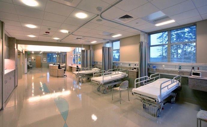 Hospital patient care bay with beds, privacy curtains and headwall medical gas outlets